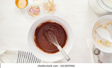 Flat lay. Step by step. Mixing ingredients together in a white mixing bowl to make unicorn chocolate cupcakes with buttercream frosting. - Powered by Shutterstock