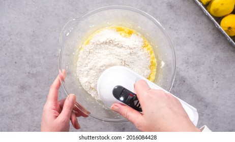 Flat lay. Step by step. Mixing ingredients in a glass mixing bowl to prepare lemon cranberry bundt cake.