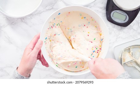 Flat lay. Step by step. Mixing in colorful sprinkles into the cake batter to make funfetti cake.