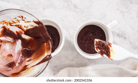 Flat lay. Step by step. Pouring chocolate cake batter into the cups to prepare chocolate mug cake.