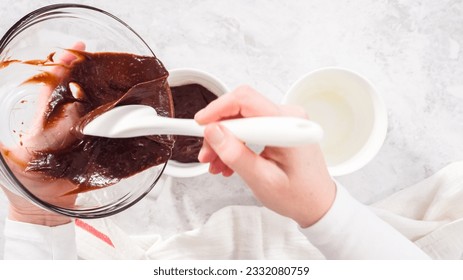 Flat lay. Step by step. Pouring chocolate cake batter into the cups to prepare chocolate mug cake.