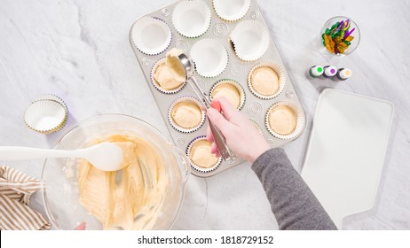 Flat lay. Step by step. Scooping cupcake batter into a foil cupcake liners to bake vanilla Mardi Gras cupcakes. - Powered by Shutterstock