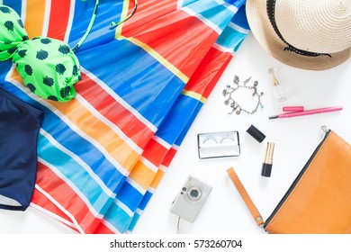 Flat Lay Of Summer Fashion With Green Color Swimsuit, Colorful Beach Umbrella And Girl Accessories On White Background