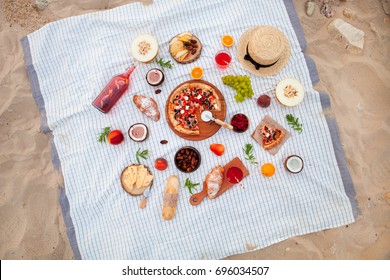 Flat lay Summer Picnic on the beach at sunset in the white plaid, food and drink conception. Top view
