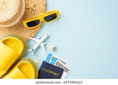 Flat lay of summer travel items including hat, yellow sandals, sunglasses, passport, and airplane models on a blue background