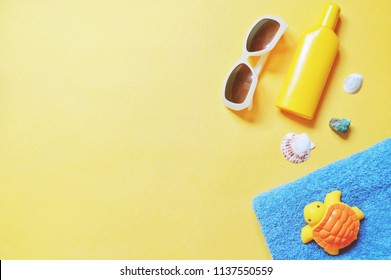 Flat Lay Summer Travel Photo. Trendy Sunglasses, Yellow Sunscreen Bottle, Seashells, Blue Towel And Turtle Toy. Beach Essentials For Sea Rest