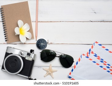 Flat Lay , Sun Glasses,camera,flower ,notebook,  With Wood White Background