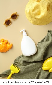 Flat Lay Sunscreen Cream Bottle For  Babies, Sun Glasses, Panama Hat, Sand Molds On Yellow Table. Sun Safety, Infant Sun Protection Concept