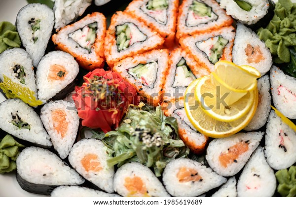 Flat lay. Sushi set, mixed rolls pattern, wallpaper or background. Horizontal format. Traditional Japanese food. Healthy Oriental meal. Wellness concept. Close up shot. Top view. Soft focus.