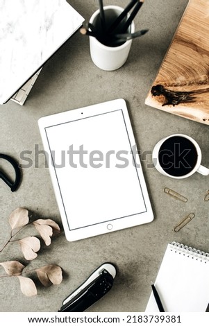 Flat lay of tablet with copy space screen mock up. Top view home office desk workspace decorated with eucalyptus, wooden board and stationery. Social media, blog, website mockup concept