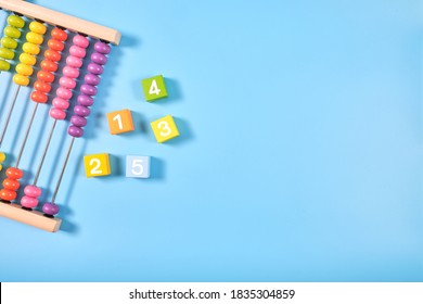 Flat lay, Top view of bright colored wooden bricks and abacus toy background with copy space for text, Numeral cubes with numbers 1 to 5 & colorful abacus, Child development, early math skills concept - Powered by Shutterstock