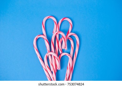 Flat lay top view of Candy canes on blue background