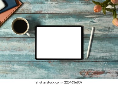 Flat lay, top view of digital tablet with white screen, coffee cup and books on rustic wooden table - Powered by Shutterstock