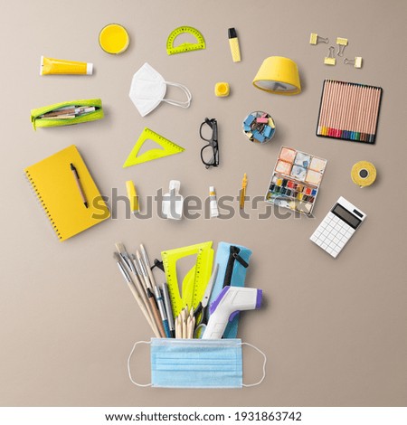 Flat lay top view of face mask and school supplies, back to school and coronavirus concept.