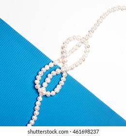 Flat Lay. Top View. Fashion And Beauty. Pearl Necklace On Creative Background