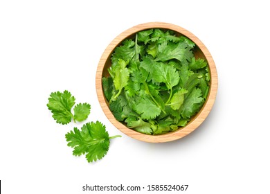 Flat lay (Top view) of fresh organic coriander chopped in wooden bowl isolated on white background. - Shutterstock ID 1585524067