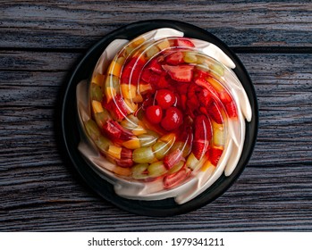 Flat lay or top view image of gelatin or transparent jelly with fruits inside on a vintage table