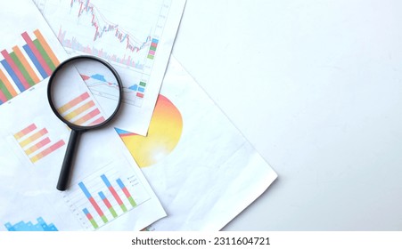 flat lay and top view a magnifying glass and graph charts document isolate on a white backdrop