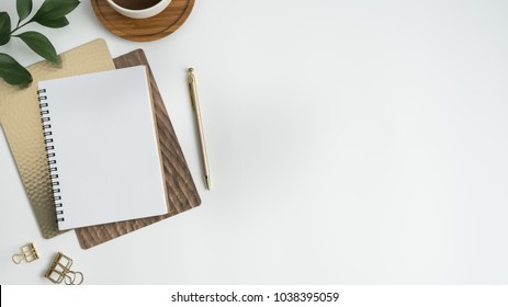 Flat lay, top view office table desk. Workspace with blank clip board, keyboard, office supplies, pencil, green leaf, and coffee cup on white background. - Shutterstock ID 1038395059