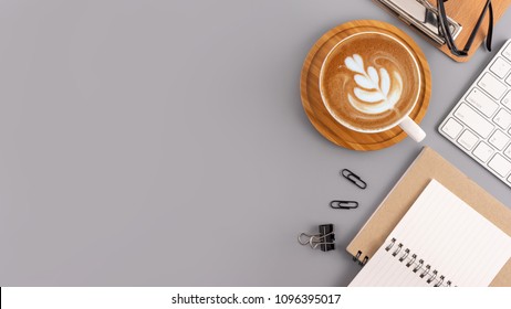 Flat Lay, Top View Office Table Desk. Workspace With Blank Note Book, Keyboard, Office Supplies And Coffee Cup On Grey Color Background.