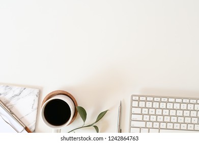Flat lay top view office desk. Workspace with keyboard and office supplies, pencil, green leaf with coffee on white background. - Shutterstock ID 1242864763