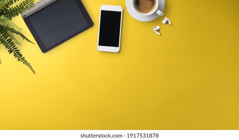 Flat Lay Top View Office Desk Working Space With Tablet On Yellow Background. Copy Space.