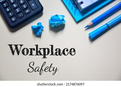 Flat lay, top view office table desk. Workspace with the text workplace safety on yellow background.