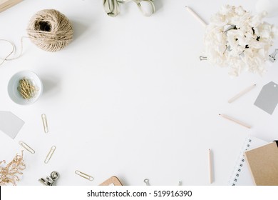 Flat Lay, Top View Office Table Desk. Feminine Desk Workspace Frame With Twine, Pencils, Floral Bouquet, Craft Diary And Clips On White Background.