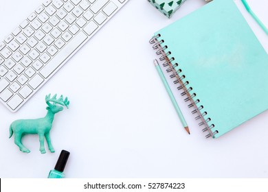 Flat Lay, Top View Office Table Desk Frame. Workspace With Laptop, Mint Candle, Mint Diary, Christmas Items And Mobile Device And Donuts On White Background.