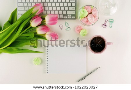 Flat lay, top view office feminine desk, female make up accessories, workspace with laptop, cup of coffee. notebook and bouquet pink tulips.Beauty blog, Holidays concept.Copy space