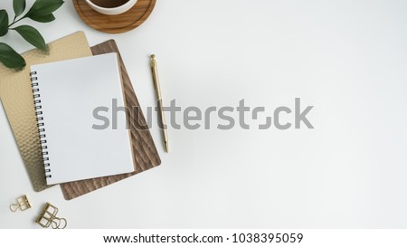 Flat lay, top view office table desk. Workspace with blank clip board, keyboard, office supplies, pencil, green leaf, and coffee cup on white background.