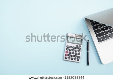 Flat lay, top view office table desk. Workspace with calculator,pen,laptop on the indigo blue background.Copy Space for text,Empty Blank to word.Business Finance,Education Technology.Work from home.