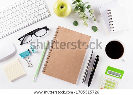 Flat lay, top view office table desk. Workspace with keyboard, office supplies, pencil, green leaf, and coffee cup with copy space on white background.