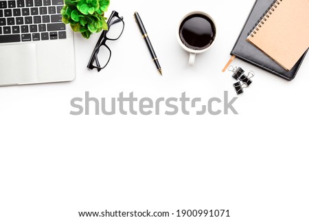 Flat lay, top view office table desk. Workspace with, laptop,office supplies, pencil, green leaf, and coffee cup on white background.
