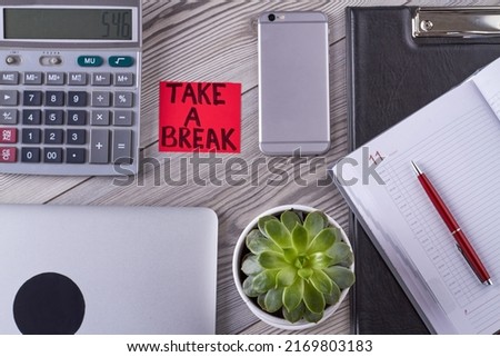Flat lay top view office desk accessories. Take a break handwriting for hardworker. Smartphone with plant and calculator.