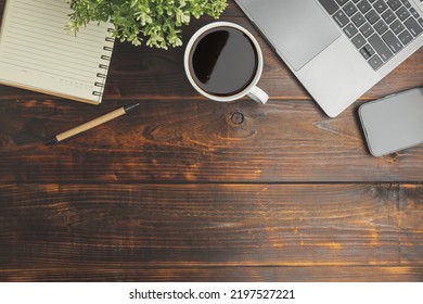 Flat Lay, Top View. Old Wood Office Table. Top View Desk Of Work Office With Laptop, Stationery, A Pen, Green Leaf, And Coffee Of Cup On Old Wooden Background With Copy Space.