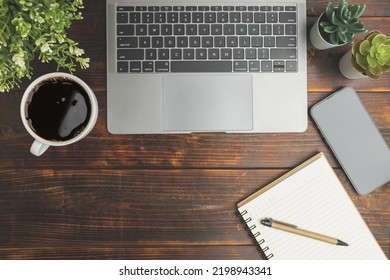 Flat Lay, Top View. Old Wood Office Table. Top View Desk Of Work Office With Laptop, Stationery, A Pen, Green Leaf, And Coffee Of Cup On Old Wooden Background With Copy Space.