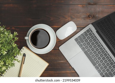 Flat Lay, Top View. Old Wood Office Table. Top View Desk Of Work Office With Laptop, Stationery, A Pen, Green Leaf, And Coffee Of Cup On Old Wooden Background With Copy Space.