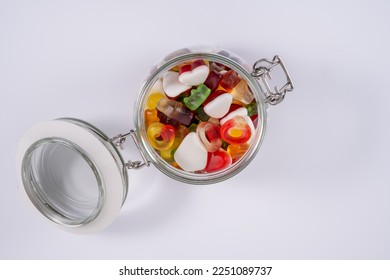 flat lay top view of an opened candy jar full of sweets candy isolated on a white background