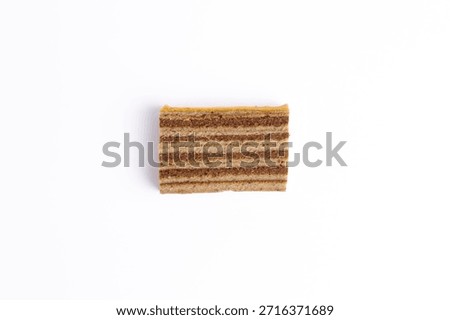 Flat lay top view single slice of Lapis Legit layer cake isolated on white background. Traditional Indonesian sweet dessert concept.
