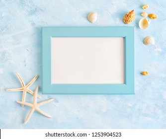 Flat Lay Top View Summer Vacation Mockup: Photo Frame, Seashells And White Starfish On Blue Background. Travel, Beach Concept. Space For Text Or Lettering