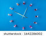 Flat lay, top view of the table. Clock from different colors and the artist