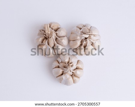 Flat lay top view of three fresh garlic bulbs isolated on white background. Spicy organic cooking ingredient concept.
