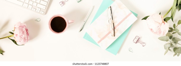 Flat Lay Top View Women's Office Desk With Flowers. Female Workspace With Laptop, Peonies, Accessories, Notebook, Glasses, Cup Of Coffee On White Background. Holiday Background.Copy Space Banner