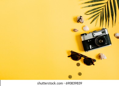 Flat lay traveler accessories on yellow background with palm leaf, camera and sunglasses. Top view travel or vacation concept. Summer background. - Shutterstock ID 690839839