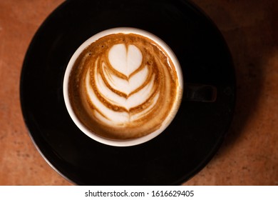 Flat lay of a tulip pattern on a cafe latte