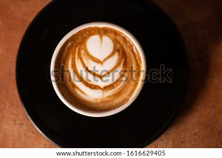 Flat lay of a tulip pattern on a cafe latte