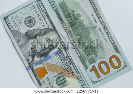 Flat lay of two one hundred 100 dollars banknotes bills greenbacks showing obverse and reverse sides on white background. Paper banknote, money, cash, currency, savings, finance. Close-up, top view.