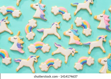 Flat lay. Unicorn sugar cookies decorated with royal icing and food glitter on a blue background.