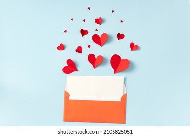 Flat Lay Valentines Day, Wedding Or Mother's Day Greeting Card Concept. Open Envelope With Empty Sheet Of Paper And Beautiful Red Cute Paper Hearts On Blue Background Top View